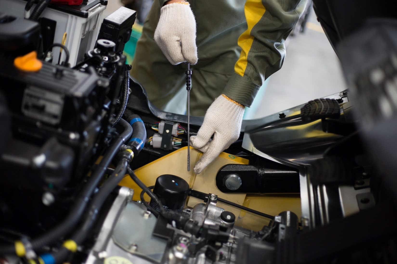 Hands performing forklift maintenance